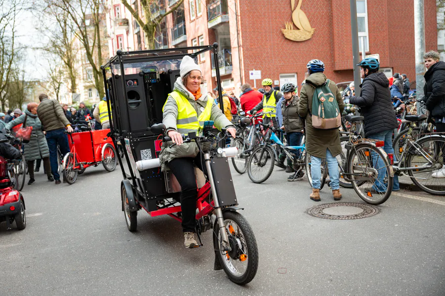 Eine Teilnehmerin fährt mit einem Lastenrad bei einer Fahrraddemonstration.